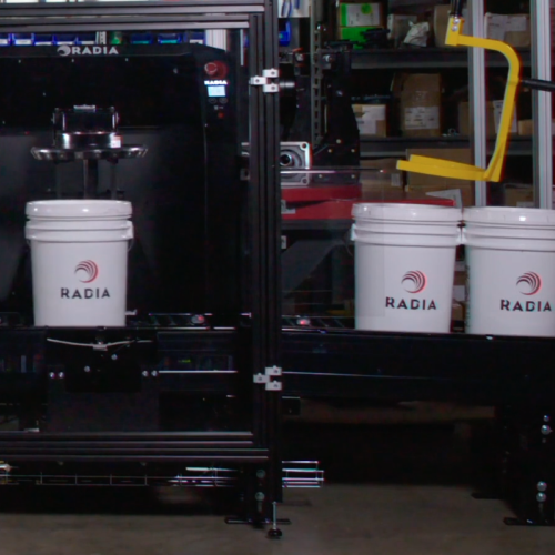 Automated paint mixing machines with lift system from Radia in an industrial setting.