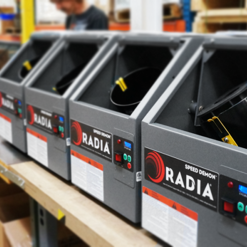 Industrial paint mixers lined up in a production facility, each with manual loading hatches.